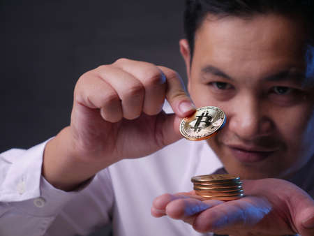 Businessman stacking physicalon his hand, investment in cryptocurrency conceptの写真素材