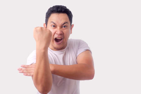 Photo image of funny Asian man showing cynical unhappy angry facial expression putting up his fist challenge to fightの写真素材