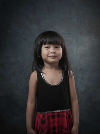 Portrait of young small baby girl smiling, over dark grunge backgroundの写真素材