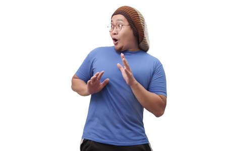 Portrait of young Asian man shocked to see something on his side, excited gesture with copy spaceの写真素材