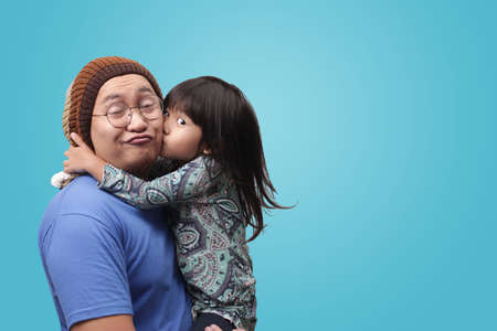 Asian young dad and his daughter have fun, while being carried in his father's arms, happy familyの写真素材