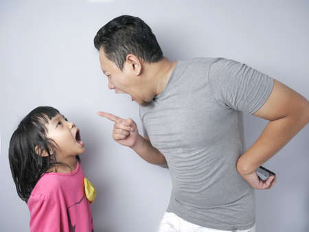 Young Asian father and little baby girl daughter arguing, screaming each other, dad mad at his kid