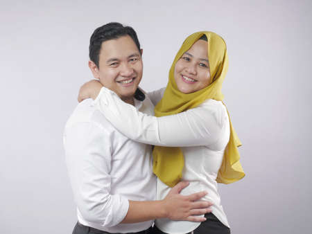 Portait of happy Asian muslim couple smiling, husband and wife hugging full of love, family conceptの写真素材
