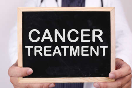 Cancer Treatment. Male doctor holds chalkboard with health typography quotes written on it. Health...