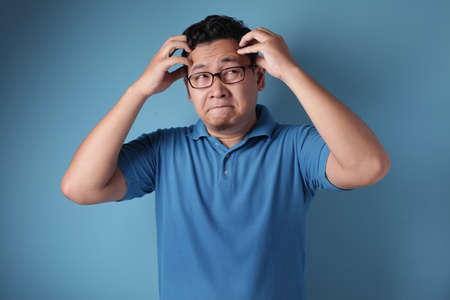 Portrait of good looking young Asian man stress or having pain of headacheの写真素材