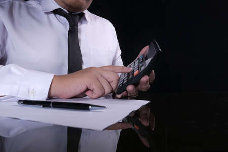 Close up image of anonymous businessman accountant doing coounting activity, calculating on calculatorの写真素材