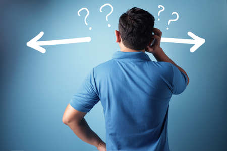 Close up rear view image of a man facing blue wall, men's back, thinking gestureの写真素材