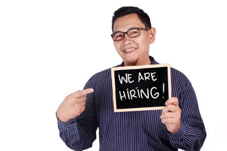 Portrait of happy smiling Asian businessman shows We Are Hiring announcement, hiring recruitment conceptの写真素材
