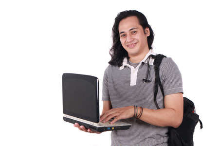 Successful young Asian student smiling at camera while holding a Laptop. Isolated on white. Half body portrait.の写真素材