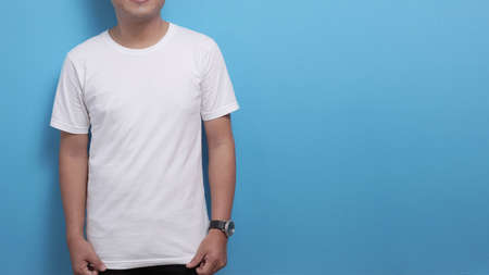 White shirt template, Asian male model wearing t-shirt with copy space against blue background,...