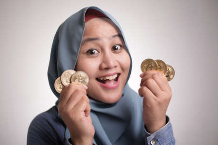 Female shows physical bitcoin currency coins, investment in cryptocurrency conceptの写真素材