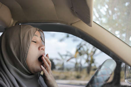 Female Asian muslim driver sleeping while driving a car, dangerous traffic safety accident crash car...