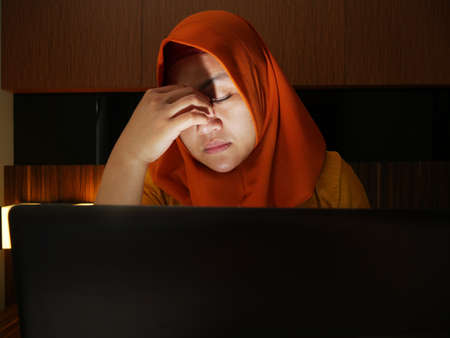 Sad muslim businesswoman crying expression to see bad financial report on laptop, loss in stock market conceptの写真素材