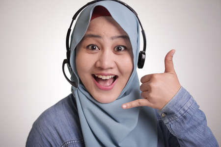 Portrait of beautiful young muslim lady wearing hijab, call center operator lady consultant smiling...