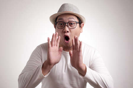 Portrait of funny young Asian man shouting and yellingの写真素材