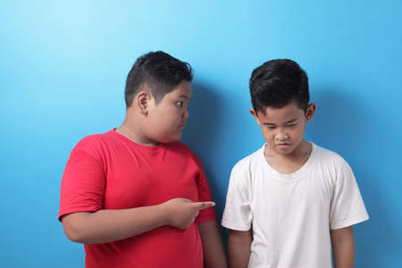 Big boy bullying small kid, school kid fight, student bully conceptの写真素材