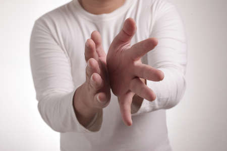 Young Asian man wearing white shirt, happy proud clapping gesture.Over grey background, halfl body portraitの写真素材