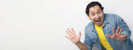Asian man surprised with big eyes and mouth open excited to see something amazing, wow amazed...