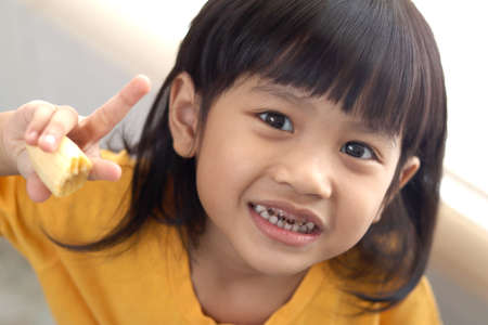 Asian little girl showing her open mouth full of caries teeth decay. Dental medicine and healthcare....