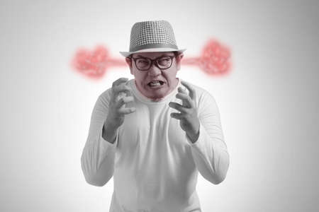 Young Asian man wearing white shirt shouting because of anger.  Close up head and shoulders