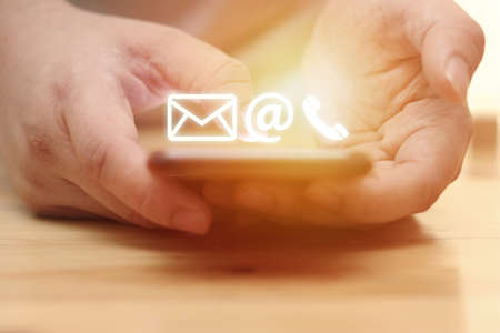 Contact us concept, man using smart phone with e-mail, mail, and phone icons graphic, selective...