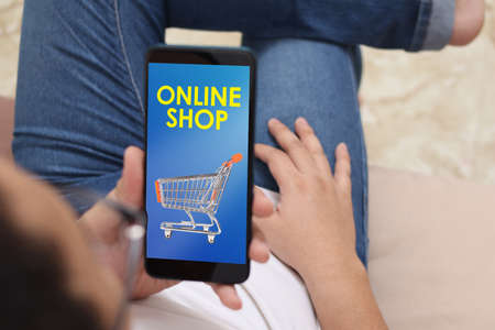 Man using smart phone, online shopping displayed on the screen, big sale, buying on internet store conceptの写真素材