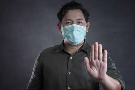 Man wearing mask to prevent coronavirus covid 19 pandemic, Asian man worried to get infected by corona virus illnessの写真素材