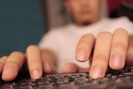 Close up of man hands fingers typing on keyboardの写真素材