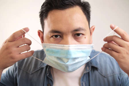 Asian man wearing medical mask coughing hard, covid-19 coronavirus patient, new normal conceptの写真素材