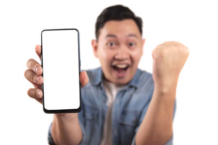 Portrait of young young Asian man presenting smart phone mockup with happy cheerful expression,...