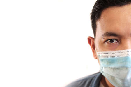 Man wearing protective facial mask. Nwe normal concept. Close up head shot portrait isolated on white with copy spaceの写真素材