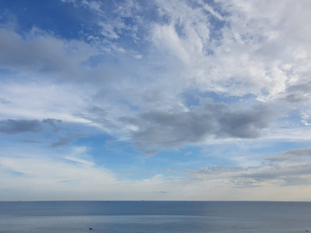 Bue ocean sea water with calm waves and cloudy sky horizon visible in the distance, natural colorの写真素材