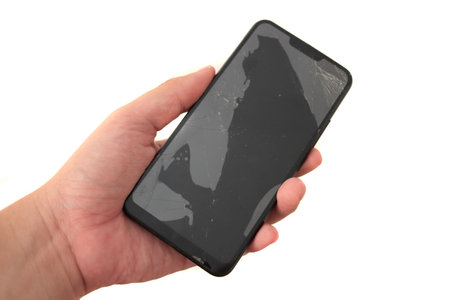 Broken phone in hand, cut out isolated on whiteの写真素材