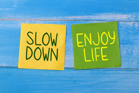 Slow down enjoy life, text words typography written on color paper against wooden background, life and business motivational inspirational conceptの写真素材