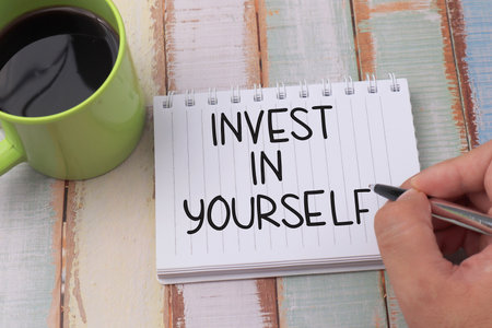 Invest in Yourself, text words typography written on book against wooden background, life and business motivational inspirational conceptの写真素材