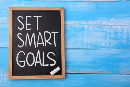 Set smart goals, text words typography written on chalkboard against wooden background, life and business motivational inspirational conceptの写真素材