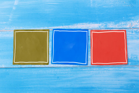 Blank colorful paper template, three piece of empty sticky paper on wooden background, copy space conceptの写真素材