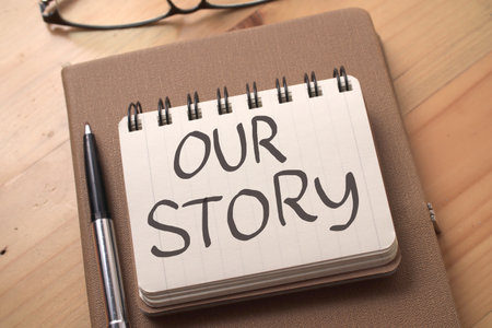 Our story, text words typography written on book against wooden background, life and business motivational inspirational conceptの写真素材