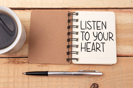 Listen to your heart, text words typography written on book against wooden background, life and business motivational inspirational conceptの写真素材