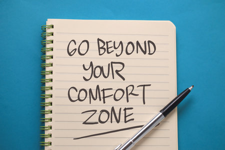 Go beyond your comfort zone, text words typography written on book against blue background, life and business motivational inspirational conceptの写真素材