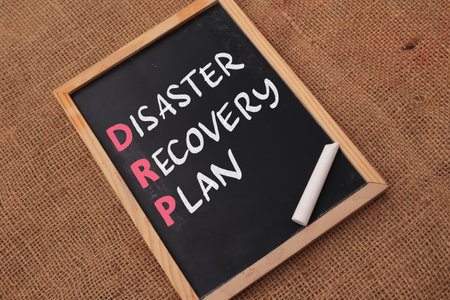 Disaster Recovery Plan, text words typography written on chalkboard against wooden background, life and business motivational inspirational conceptの写真素材