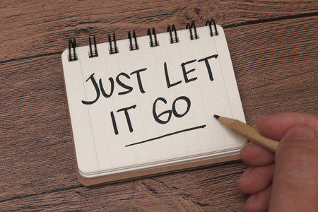 Just let it go, text words typography written on book against wooden background, life and business motivational inspirational conceptの写真素材