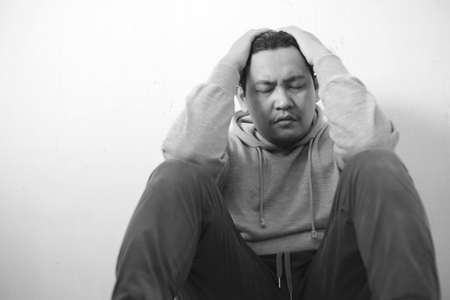 Sad depressed anxiety Asian man thinking contemplating bad thing happened in his life, stress exhausted feeling down expression, financial or relationship problem conceptの写真素材