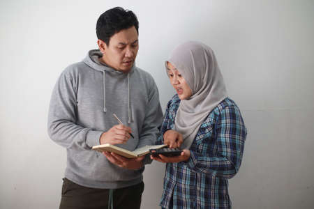 Asian young muslim couple checking analyzing their family financial management report, young family housband and wife confused to have bad financialの写真素材