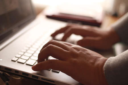 Close up of person fingers typing on laptop, business or education conceptの写真素材