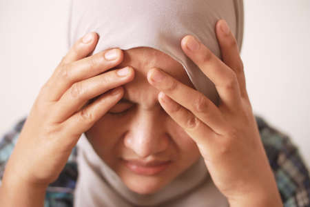 Sad depressed anxiety Asian muslim woman thinking contemplating bad thing happened in her life, stress exhausted feeling down expression, financial or relationship problem conceptの写真素材