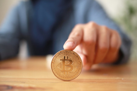 A person rolling bitcoin coin cryptocurrency on table, digital asset investment concept