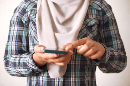 Close up of woman holding and using smart mobile phone, scrolling browsing internet on gadget conceptの写真素材