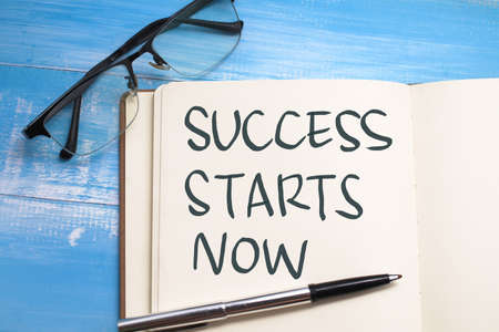 Success starts now, text words typography written on book against blue background, life and business motivational inspirational conceptの写真素材
