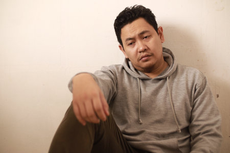 Sad depressed anxiety Asian man thinking contemplating bad thing happened in his life, stress exhausted feeling down expression, financial or relationship problem conceptの写真素材